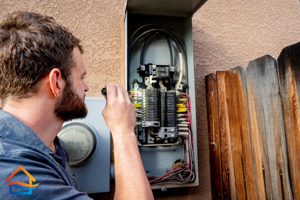 Young Male Property Inspector Photographing an Electrical Panel on a Residential Home